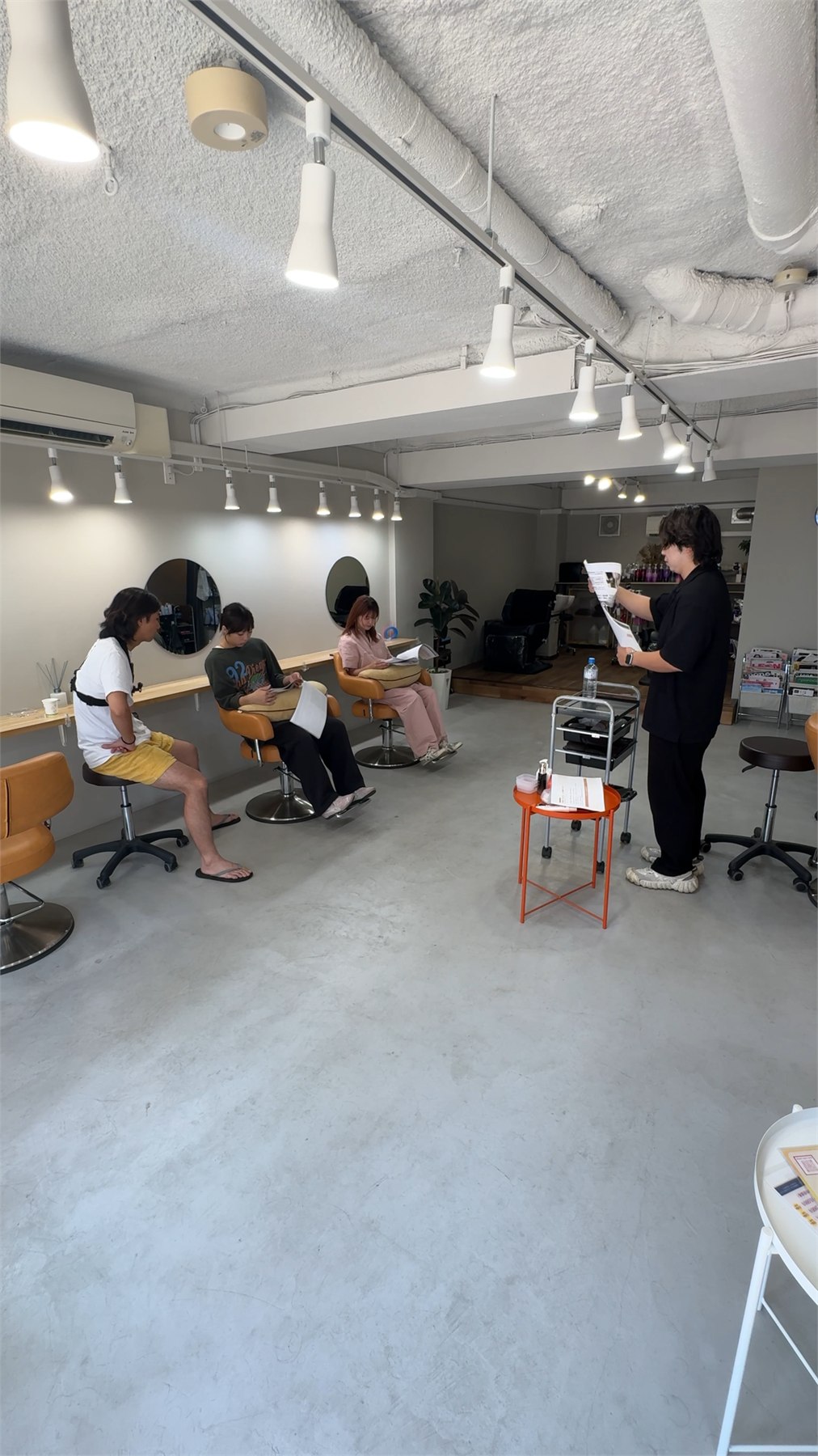 美容室内で講師と3名の受講者が店舗技術講習を行う様子
